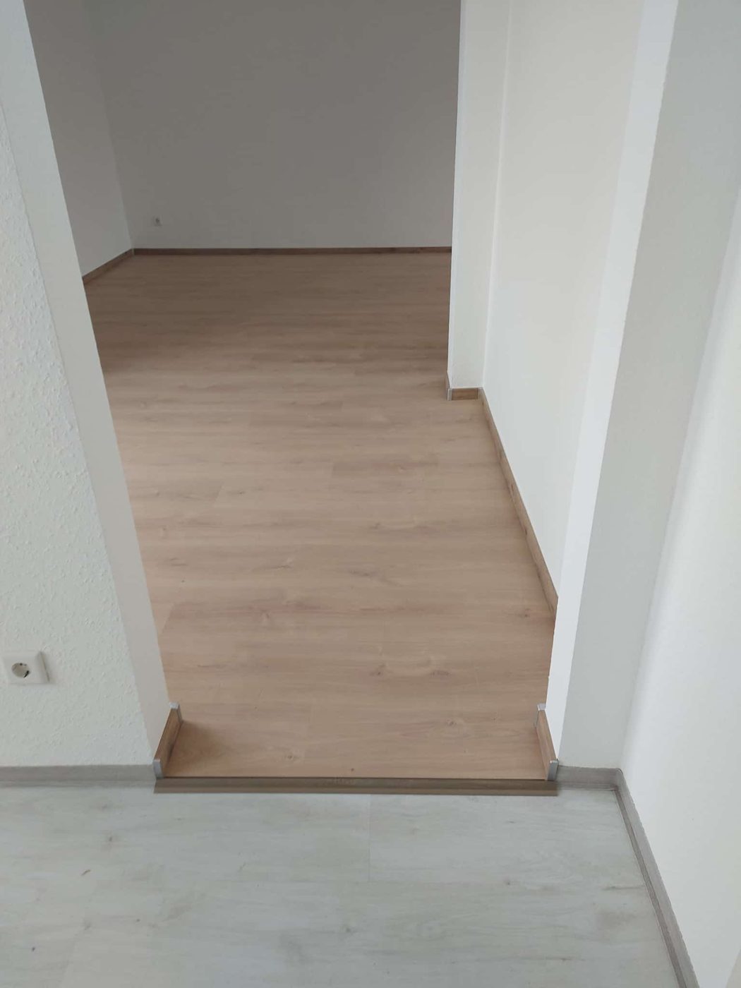 Neu verlegter Boden in Holzoptik mit Übergangsleiste